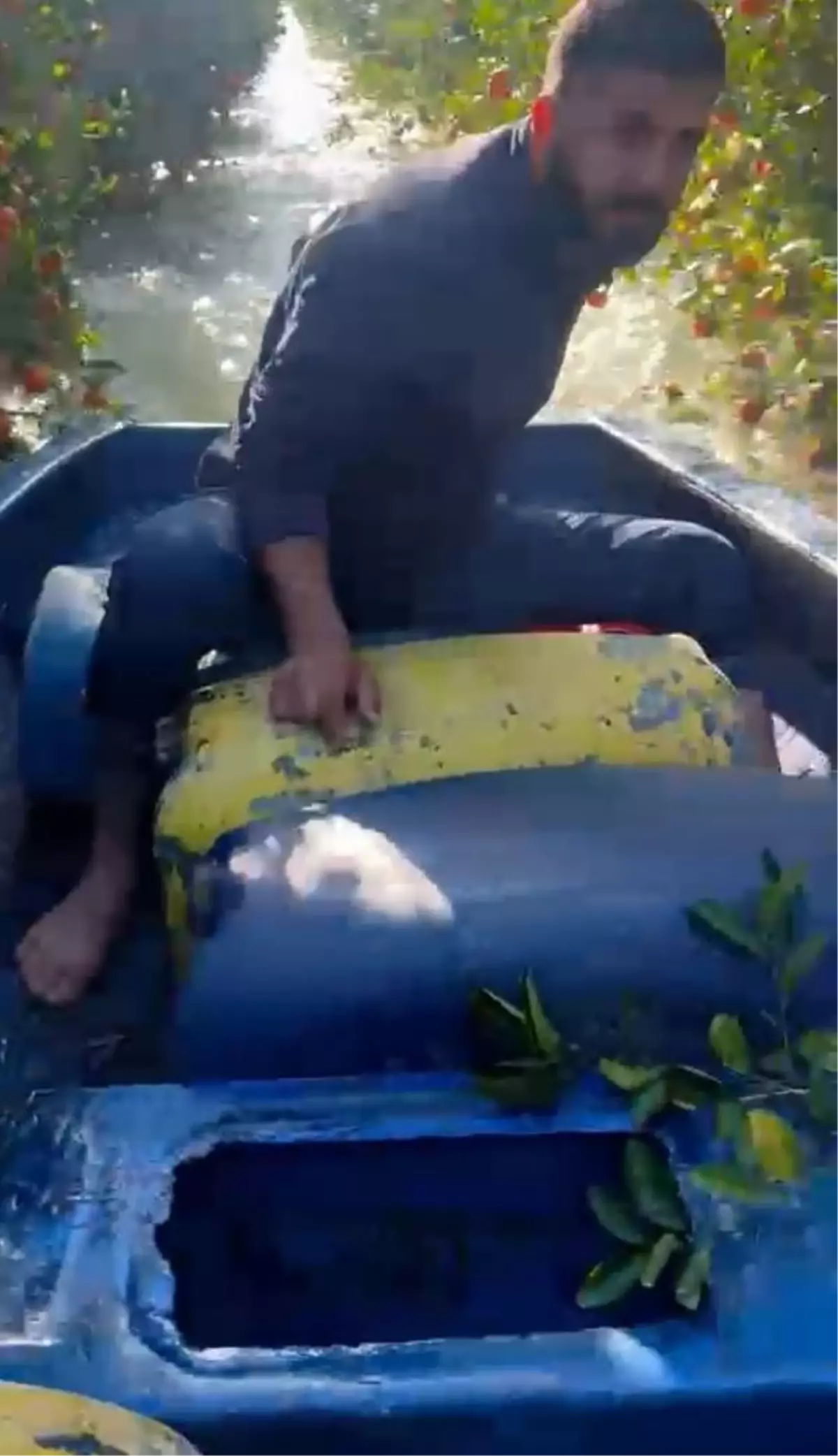 Sular altında kalan bahçesine kayıkla ulaştı